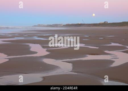 Der Mond steigt über Hartlepool Beach bei Sonnenuntergang, County Durham, England, Großbritannien. Stockfoto