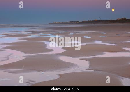 Der Mond steigt über Hartlepool Beach bei Sonnenuntergang, County Durham, England, Großbritannien. Stockfoto