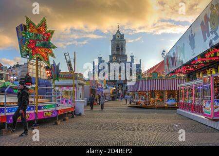 Kirmes auf dem Marktplatz (Markt) in Delft, Niederlande mit dem Rathaus im Hintergrund. Stockfoto