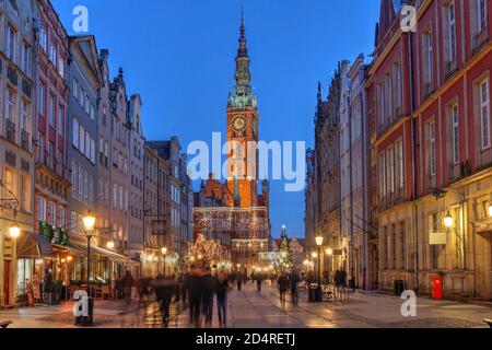 Nachtszene entlang der Dulga Straße in der Innenstadt von Danzig, Polen mit dem Rathaus der Stadt. Stockfoto