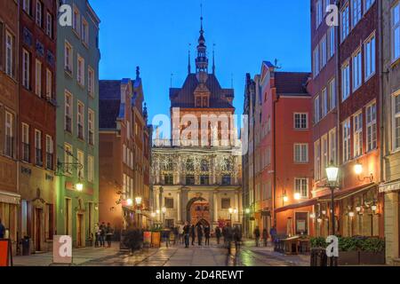 Nachtszene entlang der Dulga Straße im Zentrum von Danzig, Polen mit dem Goldenen Tor und dem Gefängnis Turm dahinter. Stockfoto