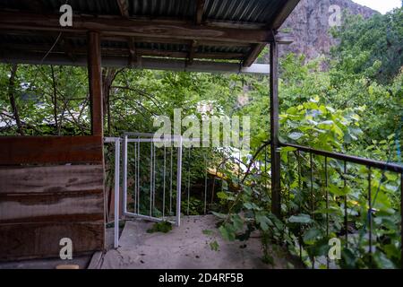 Altes beschädigtes Haus Balkon in der Nähe eines Gartens in einem Berg Dorf Stockfoto