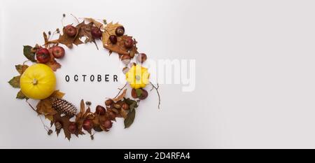 Herbstkranz mit Inschrift aus gelben Kürbissen und Blättern Stockfoto