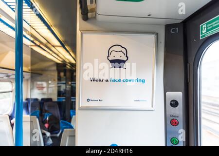 Tragen Sie eine Gesichtsmaske auf dem Plakat der öffentlichen Verkehrsmittel im Londoner South East-Zug Stockfoto