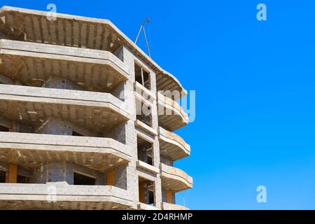 Unvollendetes mehrstöckiges Wohngebäude gegen blauen Himmel Kopierraum Stockfoto