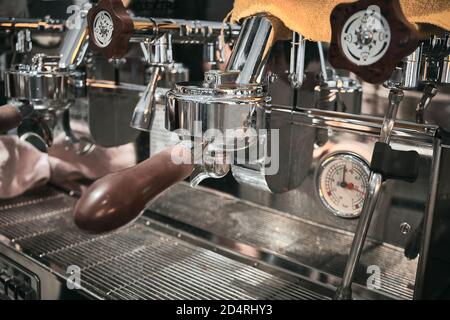 Nahaufnahme der professionellen Kaffeemaschine. Braune Griffe und verchromte Oberflächen der Kaffeemaschine Stockfoto