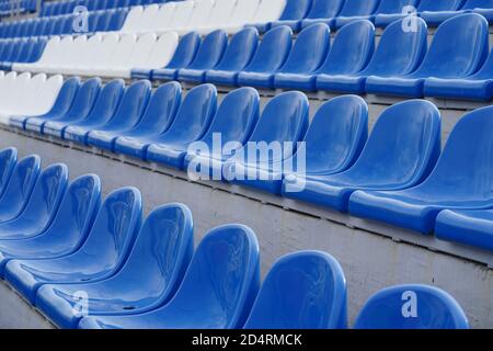 Tribüne in einem Sportstadion. Weiße und blaue Sitze in einem großen Straßenstadion. Stockfoto