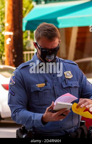 Ellicott City, MD, USA 10/07/2020: Nahaufnahme eines jungen kaukasischen Polizisten, der in Howard County arbeitet, als er ein Parkschein für einen schreibt Stockfoto