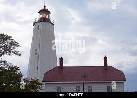 Leuchtturm in Sandy Hook, New Jersey, in der Dämmerung an einem bewölkten Tag mit seinem Licht schwach -31 scheint Stockfoto
