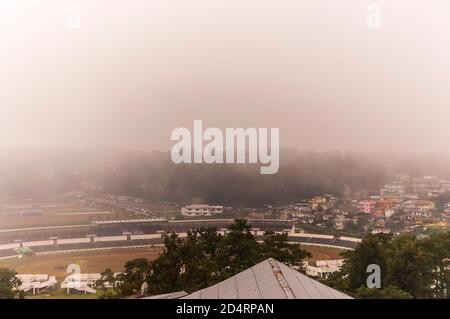 Nebel rollt in die Stadt Shillong in Meghalaya, Indien, von der anderen Seite des Berges nach einem Gewitter am Nachmittag während der Monsunsaison. Stockfoto