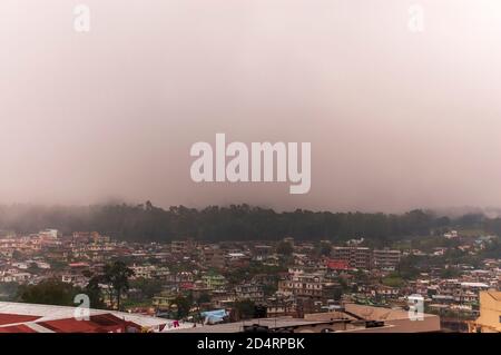 Nebel rollt in die Stadt Shillong in Meghalaya, Indien, von der anderen Seite des Berges nach einem Gewitter am Nachmittag während der Monsunsaison. Stockfoto