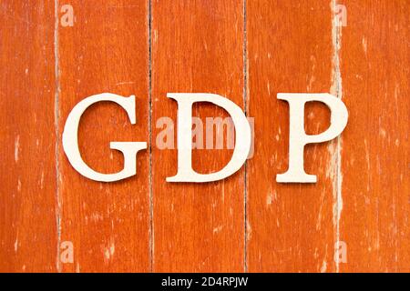 Buchstabe im Wort GDP (Abkürzung für gute Vertriebspraxis oder Bruttoinlandsprodukt) Auf alten roten Farbe Holzplatte Hintergrund Stockfoto