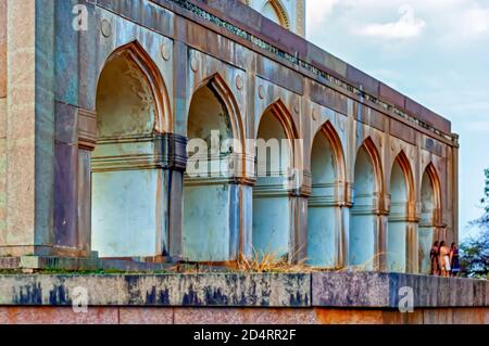 Besucher gesehen stehen außerhalb der Bögen / Torbögen im Inneren der Qutb Shahi Gräber in Ibrahim Bagh in Hyderabad, Indien. Stockfoto