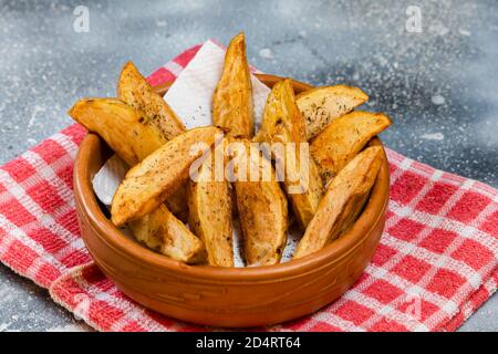 Rustikale oder Landhausstil frittierte Kartoffeln mit Kräutern in einem Keramikschale auf einer Betonoberfläche Stockfoto