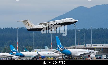 Richmond, British Columbia, Kanada. Juli 2020. Ein British Aerospace Avro RJ100 Jet (C-GSUI) von North Cariboo Air hebt vom internationalen Flughafen Vancouver ab. Im Hintergrund befinden sich zwei Air Transat-Jets, die aufgrund der COVID-19-Pandemie und des anschließenden starken Abschwungs im Flugverkehr kurzfristig gelagert werden. Quelle: Bayne Stanley/ZUMA Wire/Alamy Live News Stockfoto