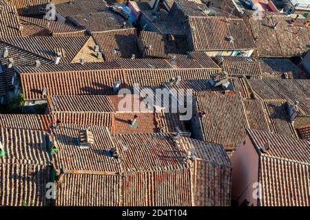 Ziegeldächer und Schornsteintöpfe eines alten italienischen Städtchens. Soriano nel Cimino. Dachhintergrund. Stockfoto