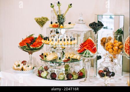 Verschiedene frische Früchte auf dem Hochzeitstisch. Tischdekoration für Hochzeiten. Obstbuffet am Empfang. Stockfoto