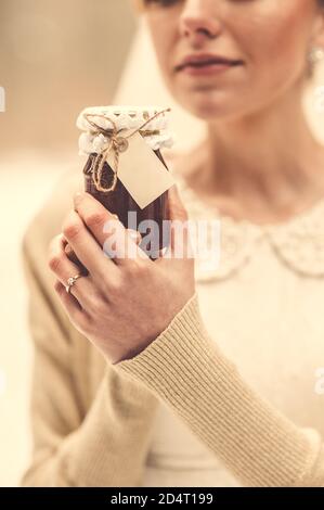 Nahaufnahme eines festlichen Krug mit Marmelade in den Händen einer jungen Braut. Vintage-Style. Stockfoto