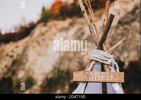 Nahaufnahme der Spitze eines Hauses mit einem Wigwam oder Zelt-Typ mit der Aufschrift auf dem Board Camper. Stockfoto