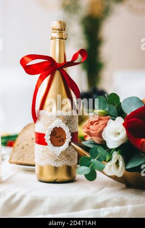 Hochzeitsflasche Champagner in Gold gemalt ist in einem rustikalen Stil dekoriert. Stockfoto