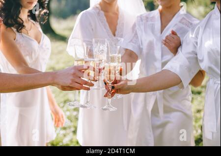 Morgen der Braut. Nahaufnahme von Gläsern Champagner in den Händen von Brautjungfern und Bräuten. Stockfoto