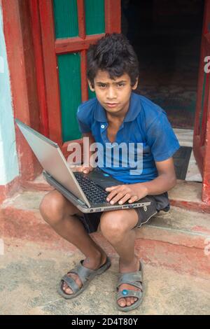 Ausbruch Des Coronavirus. Absperrung und Schulschließungen. Indische Schuljunge beobachten Online-Bildung Klassen zu Hause. COVID-19 Pandemie zwingt Kinder onl Stockfoto