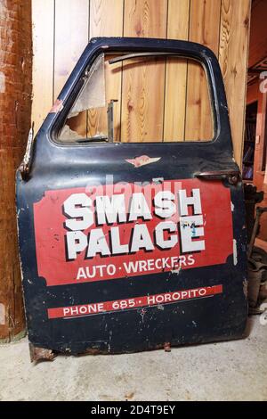 Eine Autotür mit einer Retro-Werbung für 'Smash Palace', einen riesigen Autowrackplatz in Horopito, Neuseeland Stockfoto