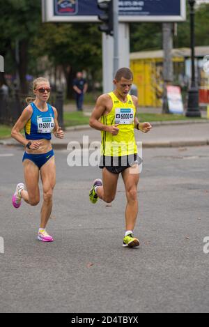 DNIPRO, UKRAINE - 16. SEPTEMBER 2018: Männliche und weibliche Führungskräfte laufen auf einer Stadtstraße während der ukrainischen Meisterschaft im Marathon unter Erwachsenen Stockfoto