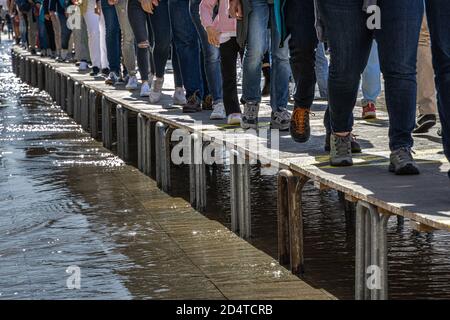 Menschen, die während der Überschwemmung in venedig auf Rampe gehen Stockfoto