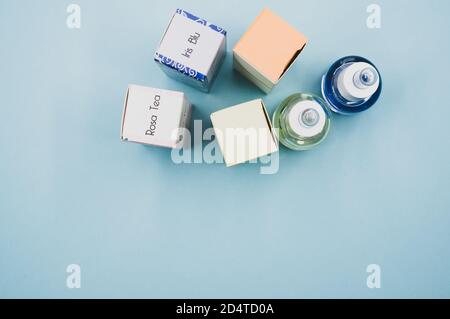 Draufsicht auf verschiedene ätherische Öle einschließlich Iris blu und Rosentee auf blauer Oberfläche Stockfoto
