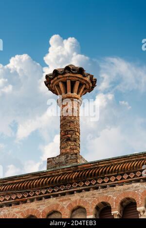 Nahaufnahme eines alten Schornsteins aus Ziegelsteinen auf einem blauen Himmel mit Wolken. Padua Innenstadt, Venetien, Italien, Europa. Stockfoto