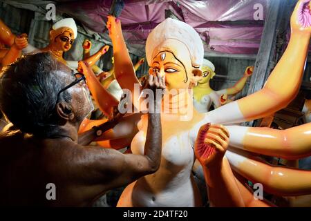 Ein achtogenarieller Künstler malt ein Idol der Hindu-Göttin Durga in Vorbereitung auf das bevorstehende hinduistische religiöse Festival Durga Puja in Kolkata. Stockfoto