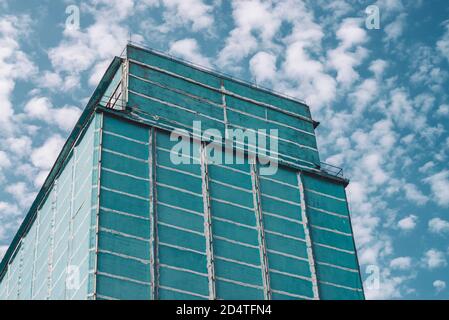 Riesige Wand des mehrstöckigen Produktionsgebäudes. Malerische alte renovierte Fabrik. Veraltertes Industrieobjekt. Fassade des großen Fertigungs Hochhaus Stockfoto