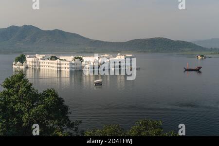 Erhöhter Blick auf Lake Pichola und Lake Palace Hotel mit Aravalli Hügel im Hintergrund an einem hellen Morgen in Udaipur, Rajasthan, Indien. Stockfoto