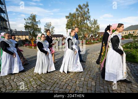 Crostwitz, Deutschland. Oktober 2020. Konfirmationskandidaten und ihre Paten gehen nach einem Konfirmationsgottesdienst um das Kirchgelände. Einige Jugendliche erhalten ihre Bestätigung in der Kirche Crostwitz. Einige Frauen tragen traditionell das sorbische Kostüm. In der katholischen Kirche ist die Konfirmation eines der Sakramente nach der Taufe und Erstkommunion. Quelle: Matthias Rietschel/dpa-Zentralbild/ZB/dpa/Alamy Live News Stockfoto