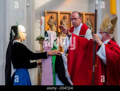 Crostwitz, Deutschland. Oktober 2020. Bischof Konrad Zdarsa (r) schenkt das Sakrament der Firmung unter den Bedingungen der Korona. In der Kirche Crostwitz erhalten etwa 40 Jugendliche eine Bestätigung. Einige Frauen tragen traditionell das sorbische Kostüm. In der katholischen Kirche ist die Firmung eines der Sakramente nach der Taufe und der ersten Kommunion. Quelle: Matthias Rietschel/dpa-Zentralbild/ZB/dpa/Alamy Live News Stockfoto