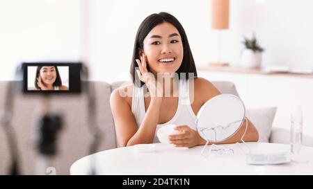 Asiatische Frau Anwendung Creme auf ihr Gesicht für sie vlog Stockfoto
