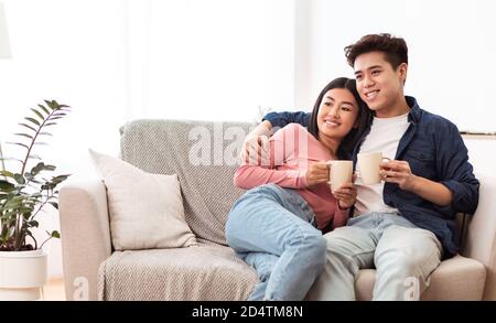 Asiatische Paar Trinken Kaffee Entspannend Sitzen Auf Couch Zu Hause Stockfoto
