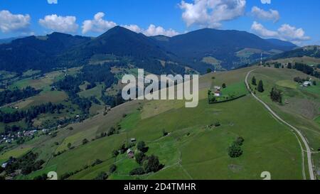 Grünes Tal mit Wiesen und Dörfern zwischen Bergen. Stockfoto