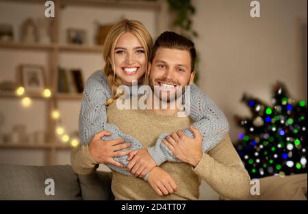 Liebevolles junges Paar feiert Weihnachten zusammen zu Hause Stockfoto