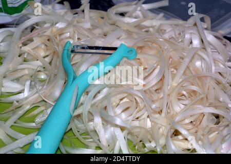 Nahaufnahme von weißen Spargelschalen und türkisfarbenem Cutter Stockfoto