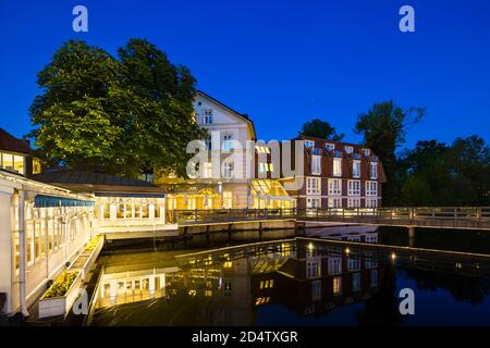 Altes Restaurant und Hotel an der Ilmenau in der Altstadt von Lüneburg, Deutschland mit nächtblauem Himmel und sauberer Reflexion. Stockfoto