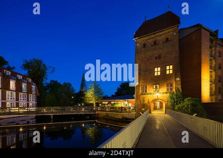 Brücke und alter Turm an der Ilmenau in der Lüneburger Altstadt mit nächtblauem Himmel. Stockfoto