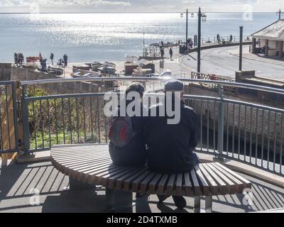 Sidmouth, Devon, 11. Okt 2020 die Menschen blicken von der neuen Alma Bridge in Sidmouth, Teil des legendären South West Coastal Path. Die alte Brücke wurde geschlossen, da die Küstenerosion ihre Fundamente bedrohte, und die Arbeiten an der Ersetzung begannen im August 2019. Aufgrund der Coronavirus-Pandemie wurden die Arbeiten bis in diesem Frühjahr erheblich verzögert. Die neue Brücke überquert den Fluss Sid, und Bewohner und Wanderer können den südwestlichen Küstenweg ohne Umleitung ins Landesinnere fortsetzen. Kredit: Photo Central/Alamy Live Nachrichten Stockfoto