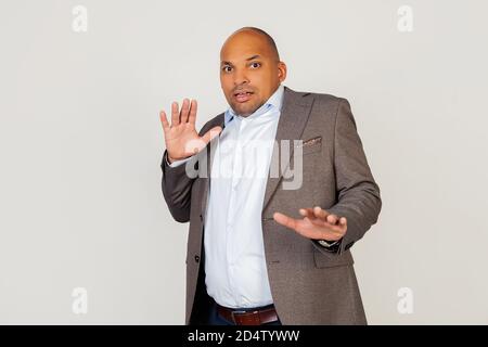 Junger afroamerikanischer Geschäftsmann schreiend mit einem verängstigten Gesichtsausdruck, ängstlich und erschrocken vor Angst Ausdruck Stop Geste mit Händen, schreiend in Schock. Panikkonzept Stockfoto