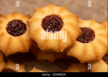 Hausgemachte Gebäck Cookies mit Marmelade auf einem Hintergrund von homespun Stoff mit einer rauen Textur, Nahaufnahme, selektive Fokus Stockfoto