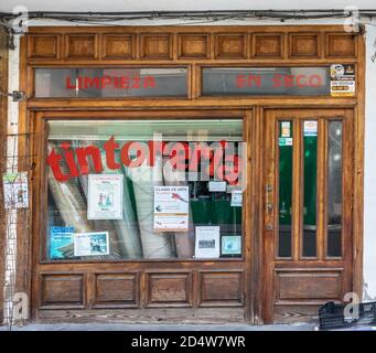 Spanien; September 2020: Außenansicht eines Trockenreinigungsladens. Alte Holztür und Fenster. Traditionelles Geschäft mit roten Buchstaben auf dem Glas. Wörter auf Spanisch 'Dry Stockfoto