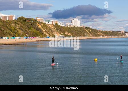 Bournemouth, Dorset, Großbritannien. Oktober 2020. Wetter in Großbritannien: Paddelboarder genießen die herrliche Abendsonne an den Stränden von Bournemouth, während die Sonne die Klippen und den Strand umspült. Quelle: Carolyn Jenkins/Alamy Live News Stockfoto