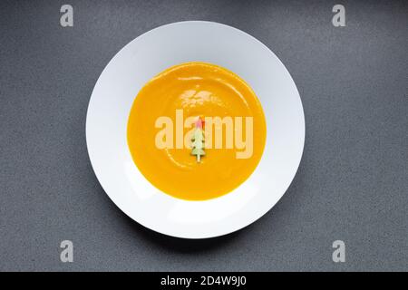 Kürbissuppe mit weihnachtsbaum geformte Gurke verziert, Draufsicht Stockfoto