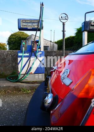 Ein klassischer MGB GT ruht vor einer verlassenen Tankstelle Stockfoto